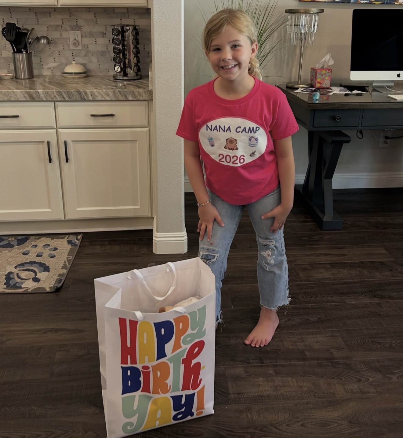 Young child holding a colorful birthday gift bag