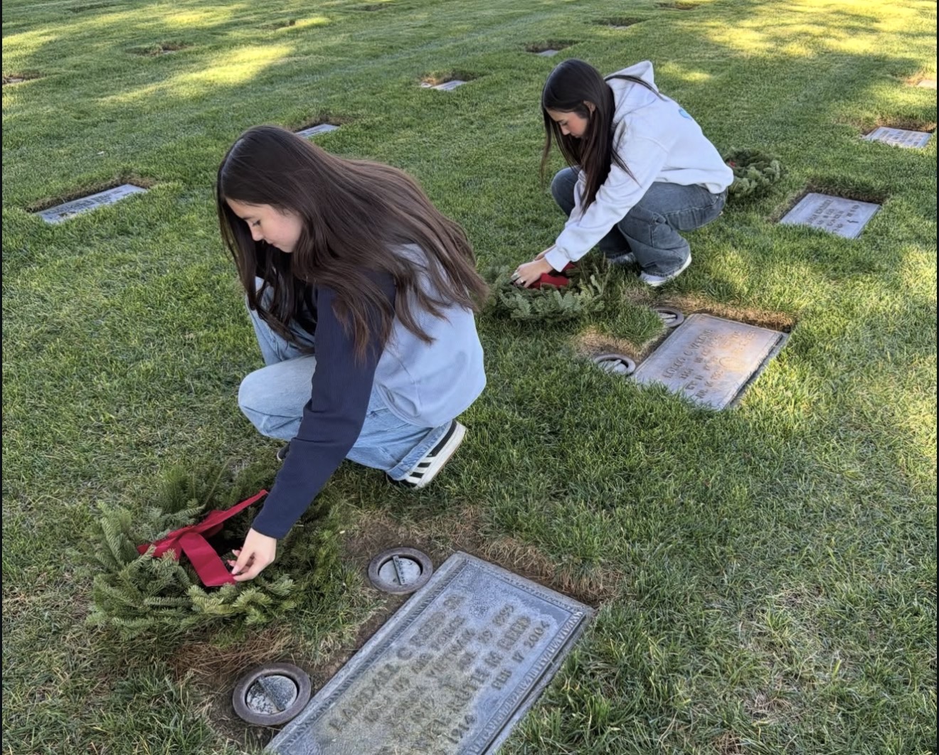 Youth volunteers placing memorial wreaths together